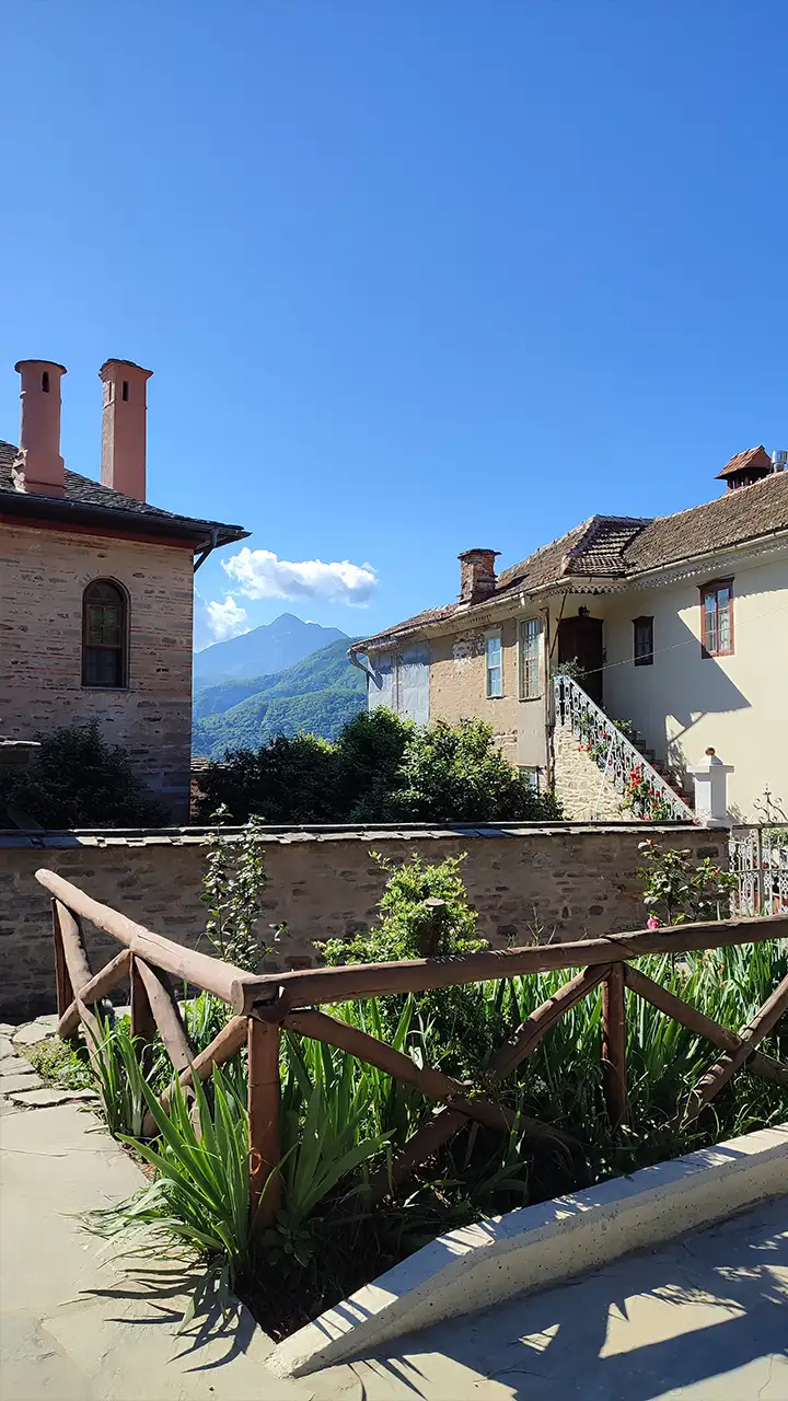 Дворик с домами в столице Афона Карьес, вдали виднеется гора Афон