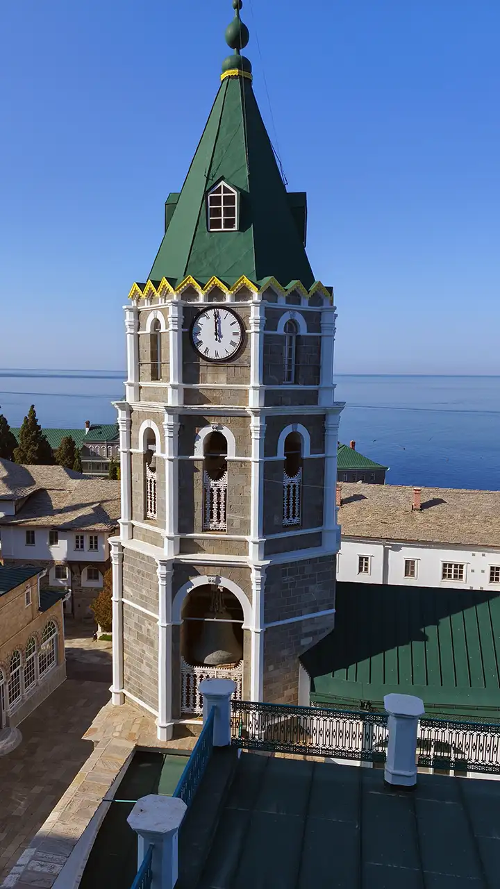 Колокольня монастыря святого Пантелеймона на Афоне с зелёной крышей и часами