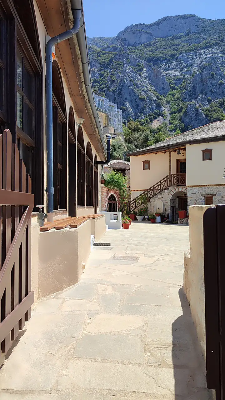 Двор скита святой Анны на Афоне с каменными постройками и горным фоном