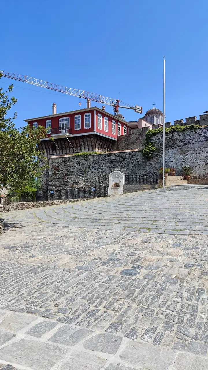 Каменные стены и красный корпус монастыря Ватопед на Афоне, вид со двора